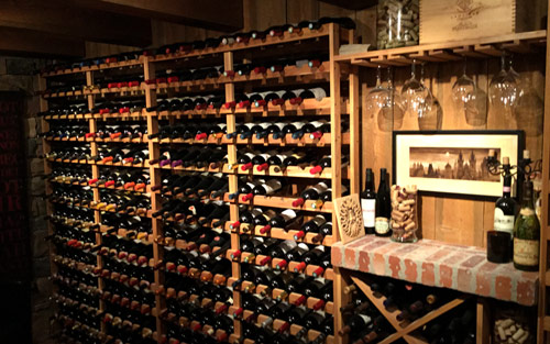 Custom built wine cellar with wooden shelves and antique decor by Mountain View Corporation in Nederland Colorado